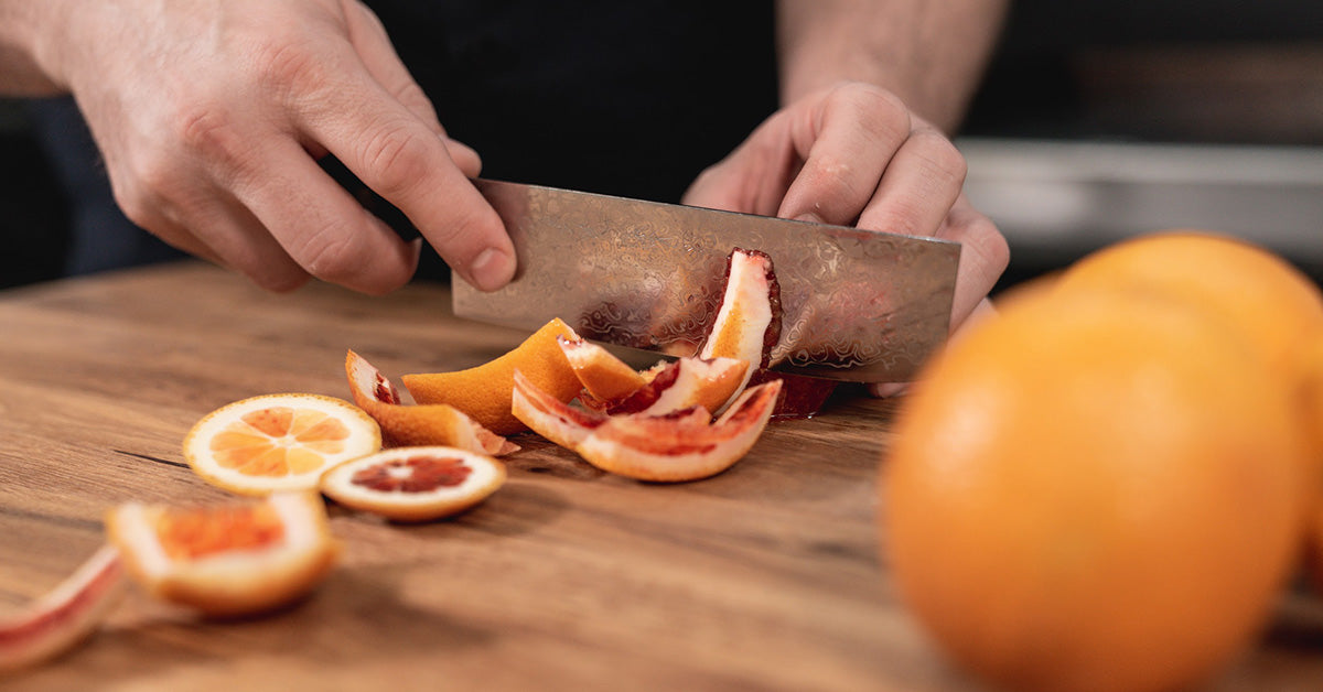 Damascus Nakiri Cutting Oranges On A Cutting Board