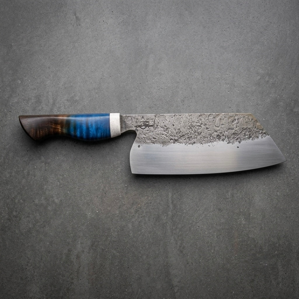 Metalwork by Meola 190 mm (7.5”) Tall Bunka handcrafted from 1084 carbon steel with a hammered forged finish, and sculpted blue flame burnished stabilized maple handle. 