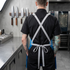 A pro chef standing in a kitchen, shown from the back, wearing a chef coat featuring Element Knife Company's 80's colorway apron showing the Cross-Back variant detail from the back.
