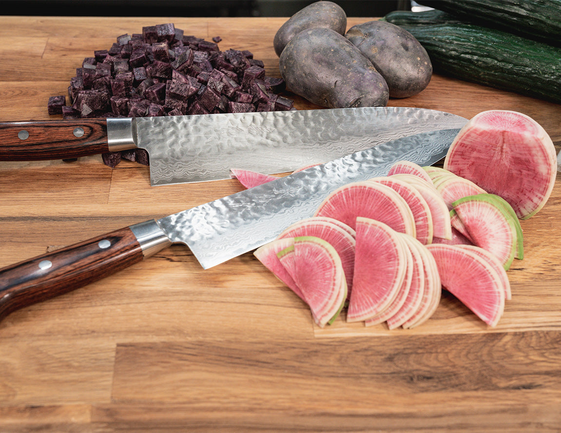 Western Style Damascus Chefs Knives on Cutting Board with sliced Vegetables