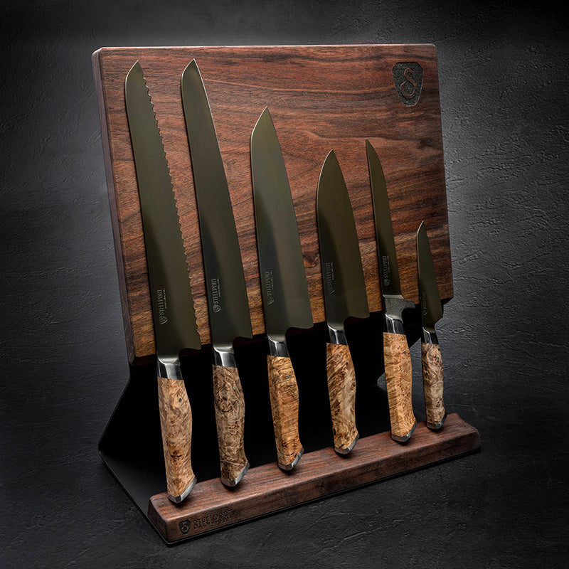 Set of knives with wooden handles on a wooden knife holder against a dark background
