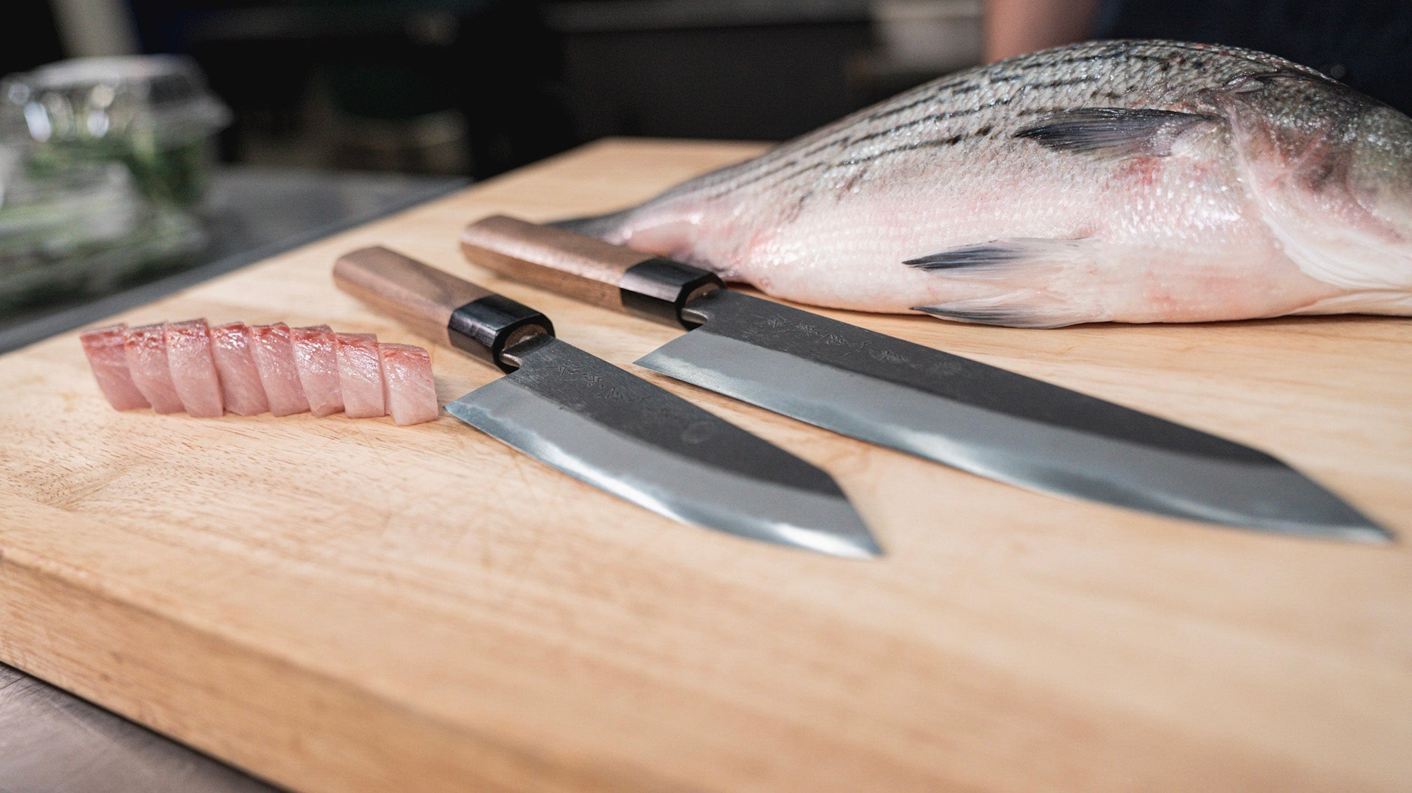 Two Knives On A Cutting Board Next To Fish